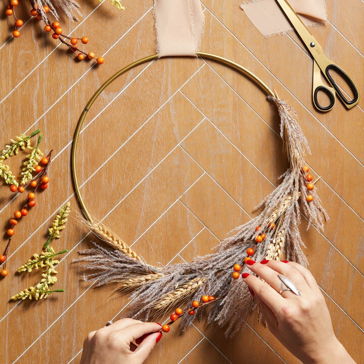autumn wreath being constructed from fall foliage and berries