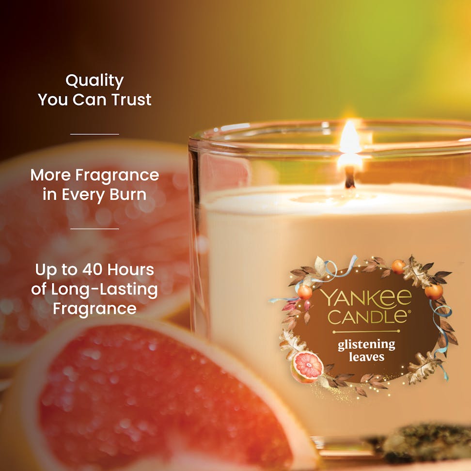 Scented candle in glass jar burning near grapefruit slices with text highlighting quality and long-lasting fragrance.