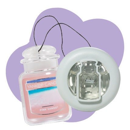 a pink sands™ car jar® ultimate and a smart scent™ vent clip in a purple background