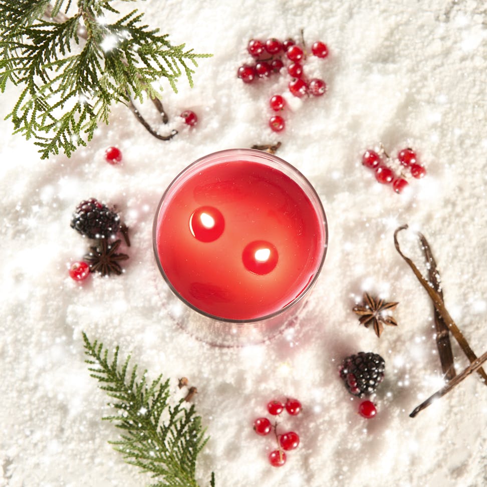 Apres Ski Collection Santa on Skis Signature Large Tumbler Candle in snow surrounded by berries and spices