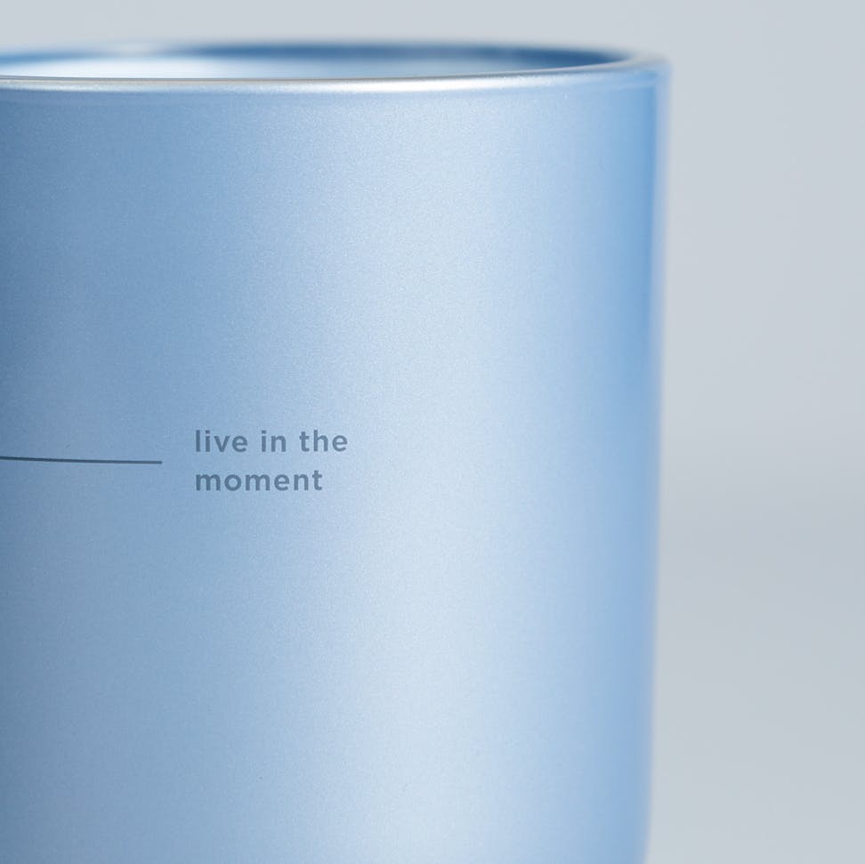 chesapeake bay candle intentions collection be present cypress sea minerals medium two wick candle in a pastel blue backdrop