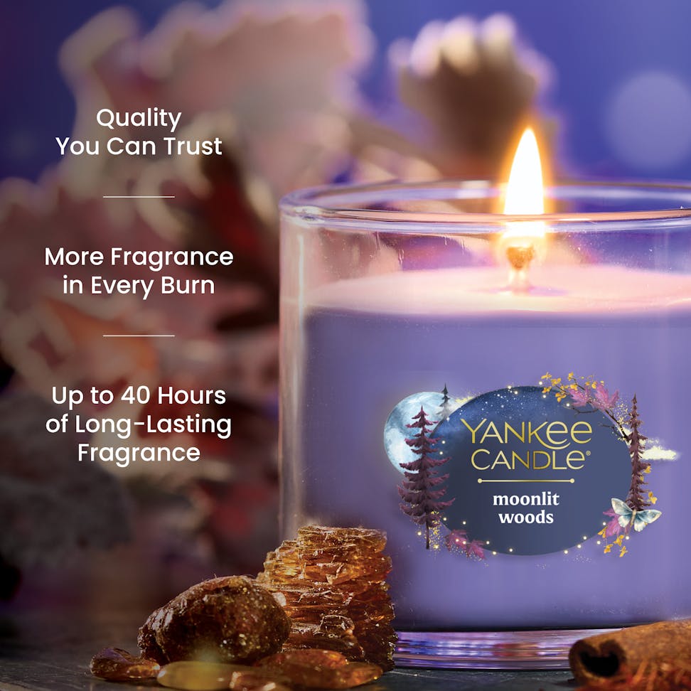 Purple scented candle in glass jar burning, with text highlighting quality, fragrance, and long-lasting burn time.
