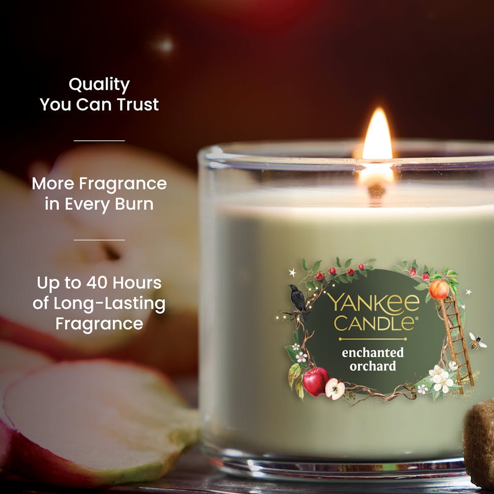 Scented candle in glass jar with apple and floral design, text highlights long-lasting fragrance and quality.