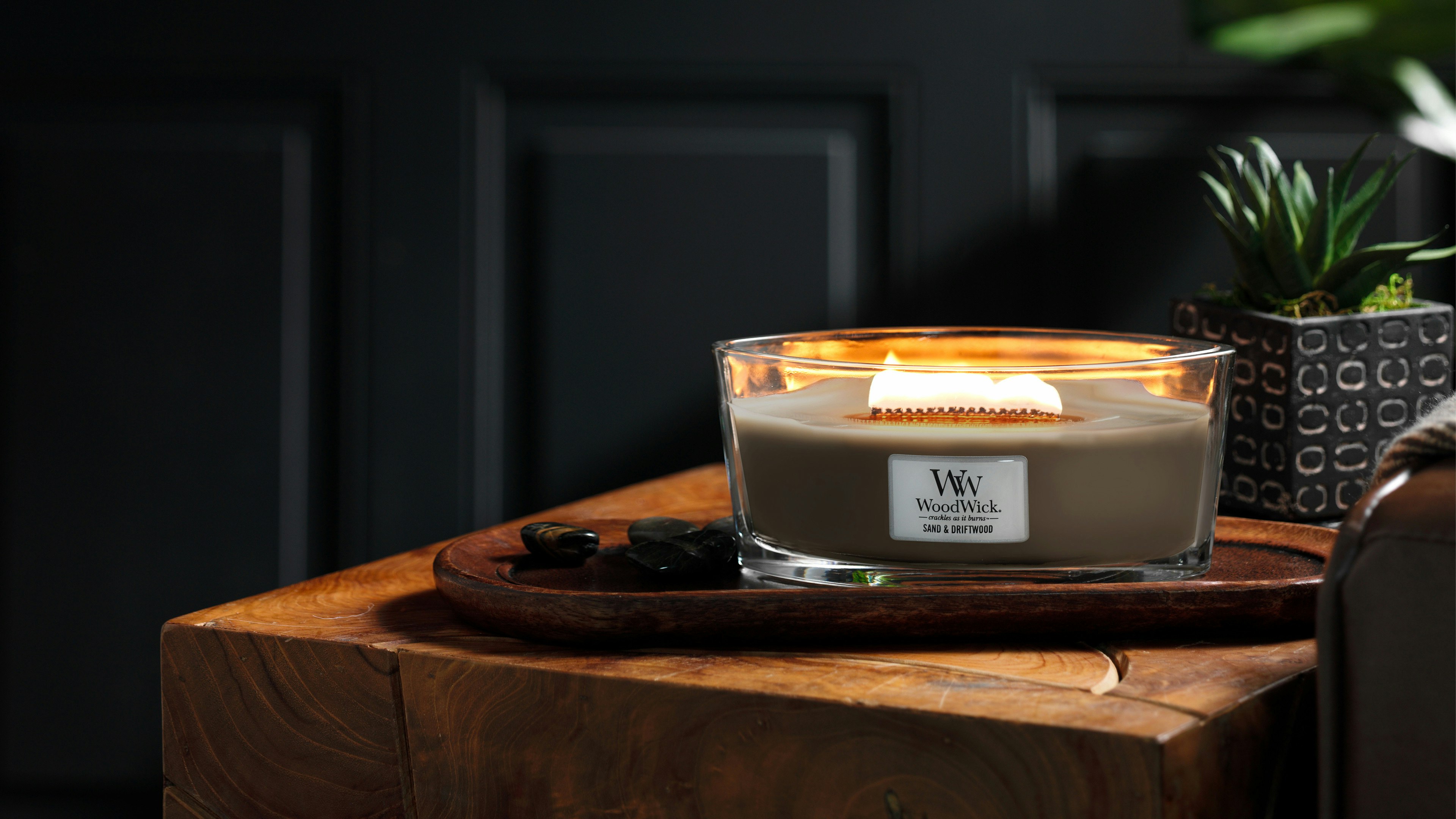 crackling candle sand and driftwood in darkened room