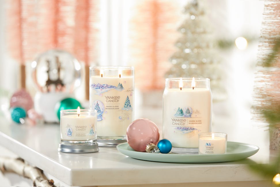 snow globe wonderland signature small tumbler candle and snow globe wonderland signature large tumbler candle and snow globe wonderland signature large jar candle and snow globe wonderland mini candle on a table in a decorative living room setting