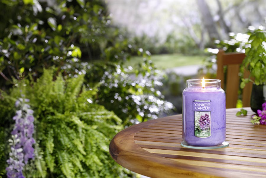 lilac blossoms large jar candle on table