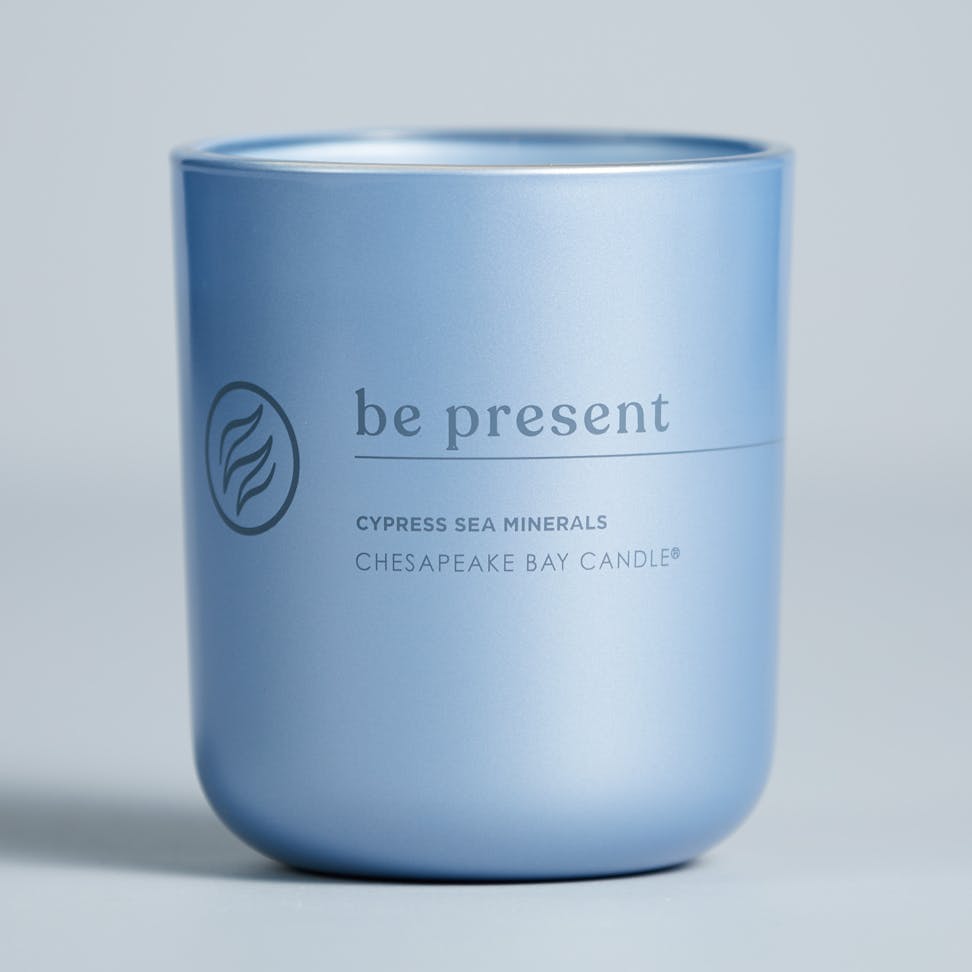 chesapeake bay candle intentions collection be present cypress sea minerals medium two wick candle in a pastel blue backdrop