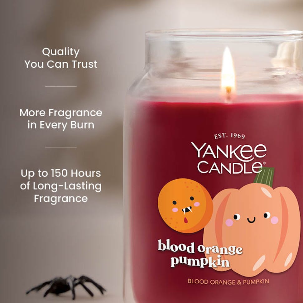 Large orange pumpkin scented candle in glass jar with text highlighting long-lasting fragrance benefits.