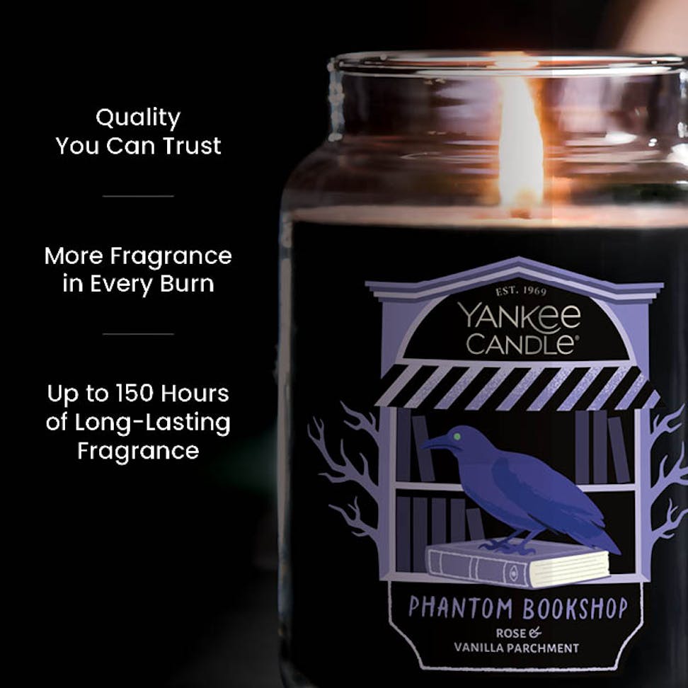 Large jar candle with burning wick, purple label, and text promoting quality, long-lasting, strong fragrance