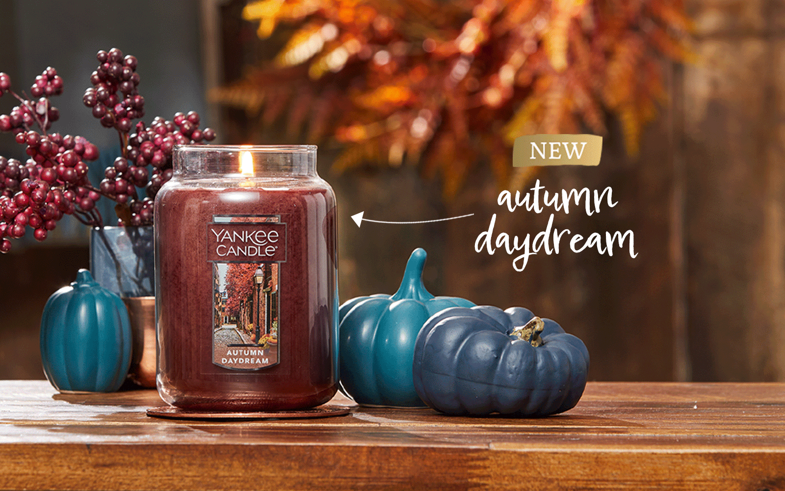 video of new autumn candles on wood table with blue pumpkins and orange wreath