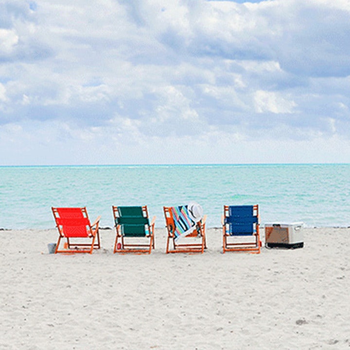 4 chairs on the beach facing the ocean