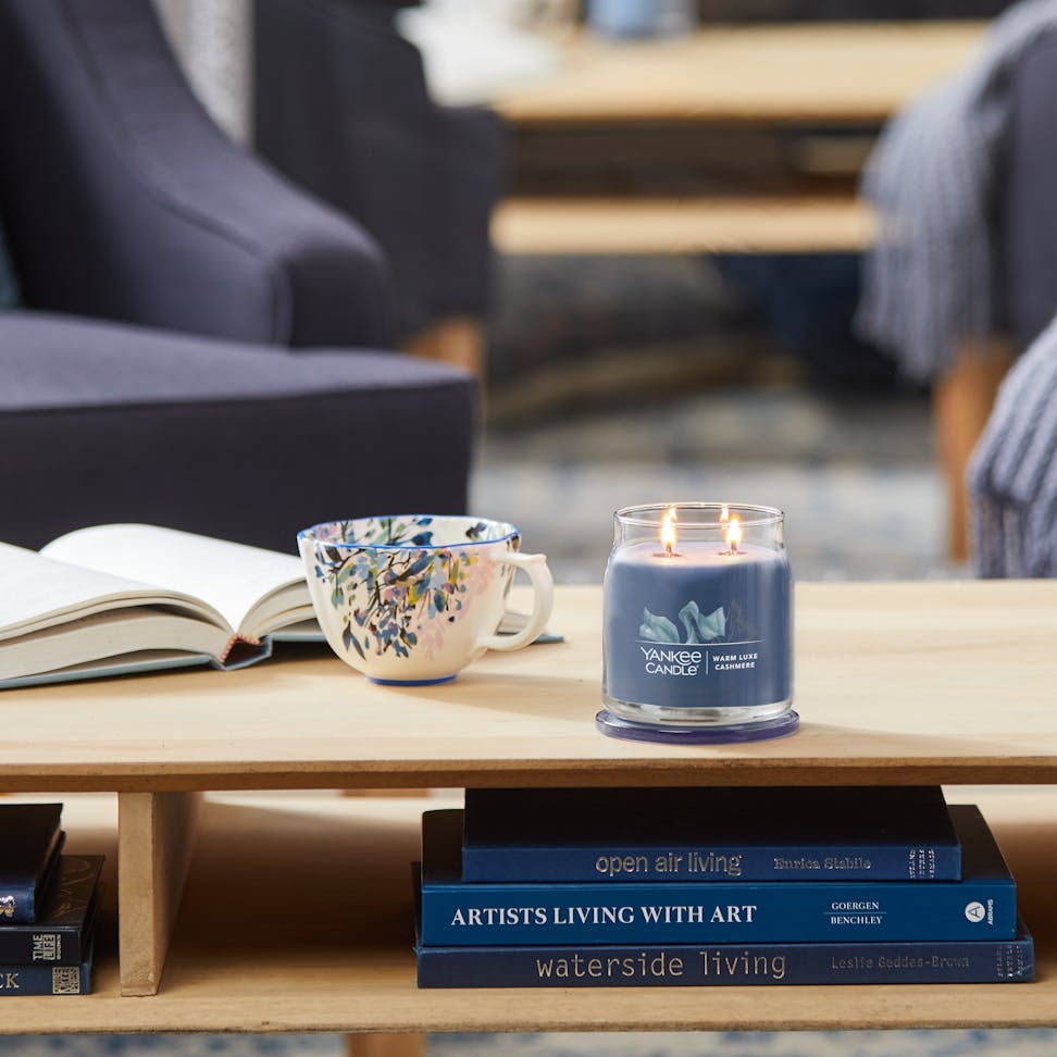 warm luxe cashmere signature medium jar candle on living room table