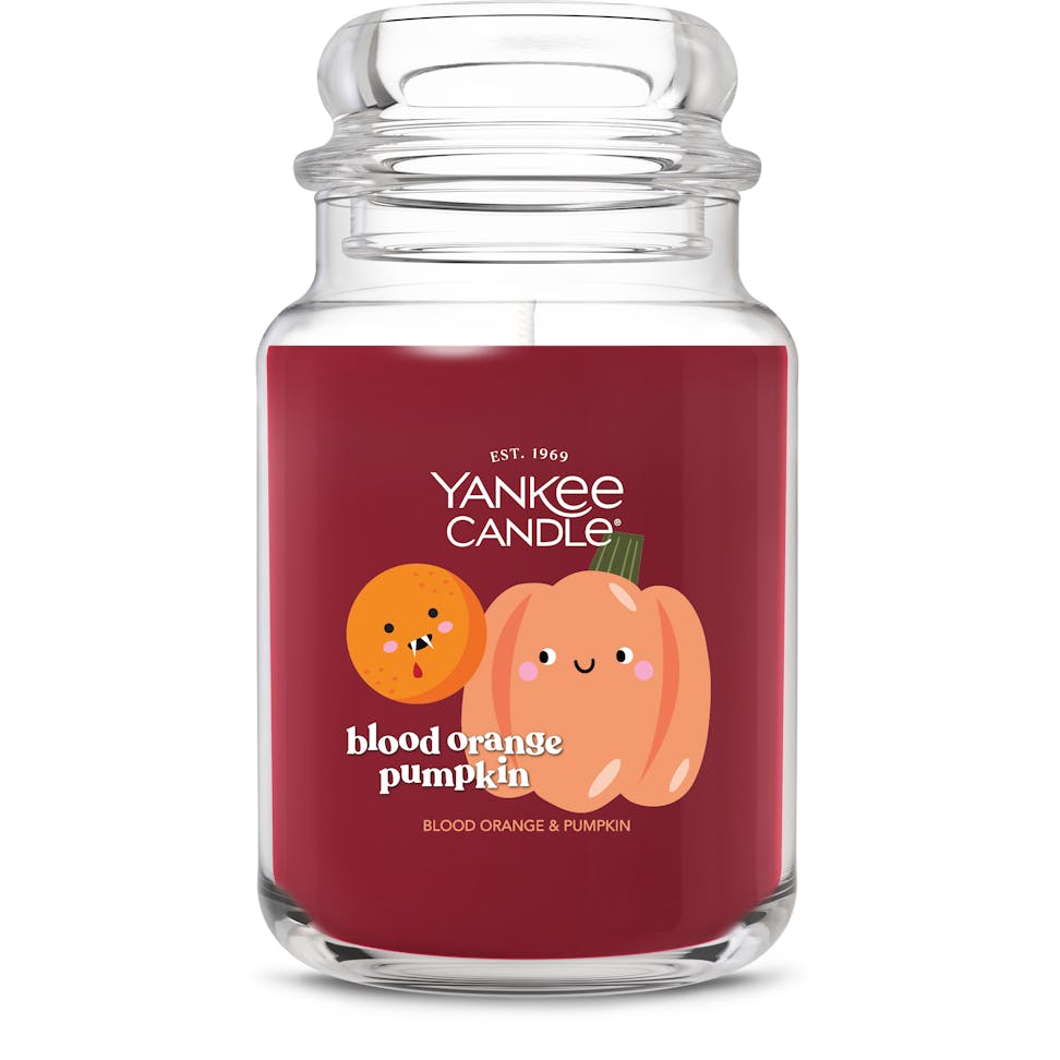 Large red jar candle with cute orange and pumpkin illustrations, labeled blood orange pumpkin scented candle.