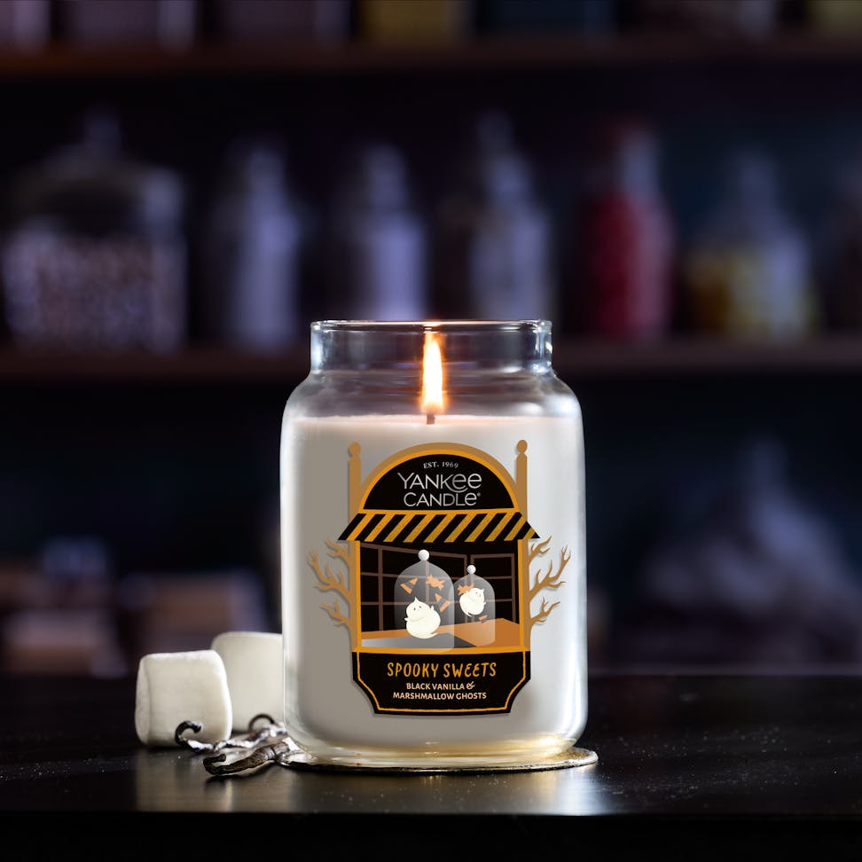 Large jar candle with a burning flame and marshmallows, perfect for home decor, relaxation, and aromatherapy.