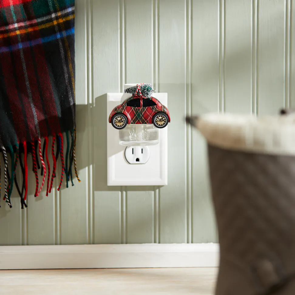 Holiday Buggy ScentPlug Diffuser plugged into a wall with a ScentPlug Refill