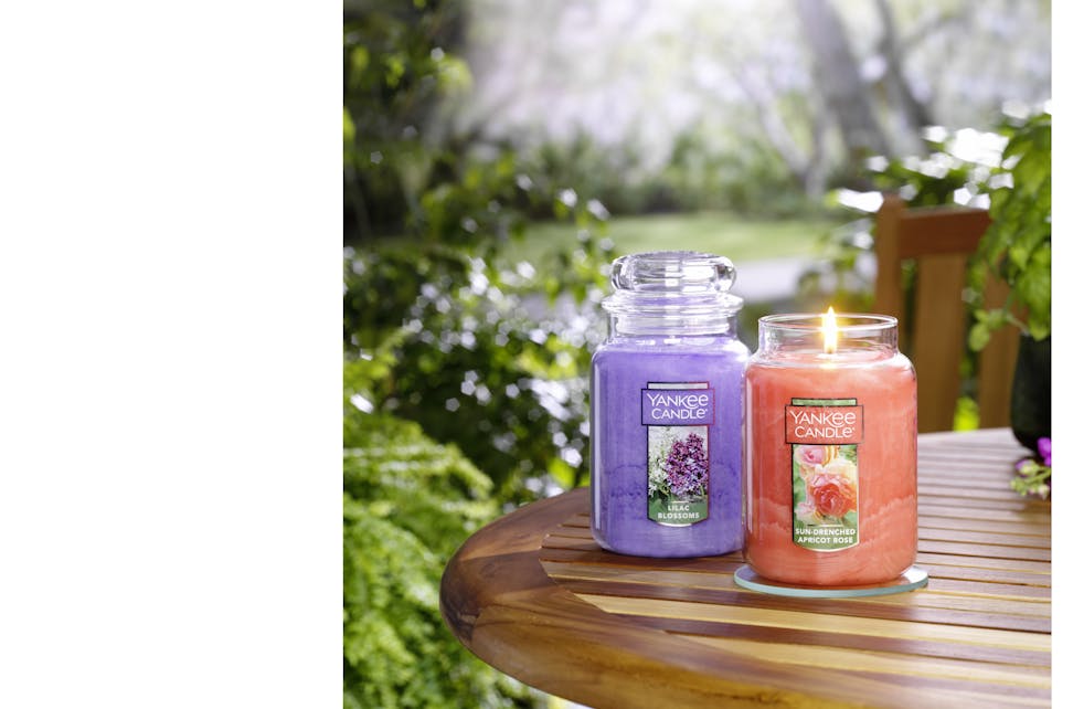 sun drenched apricot rose  lilac blossoms large jar candles on table