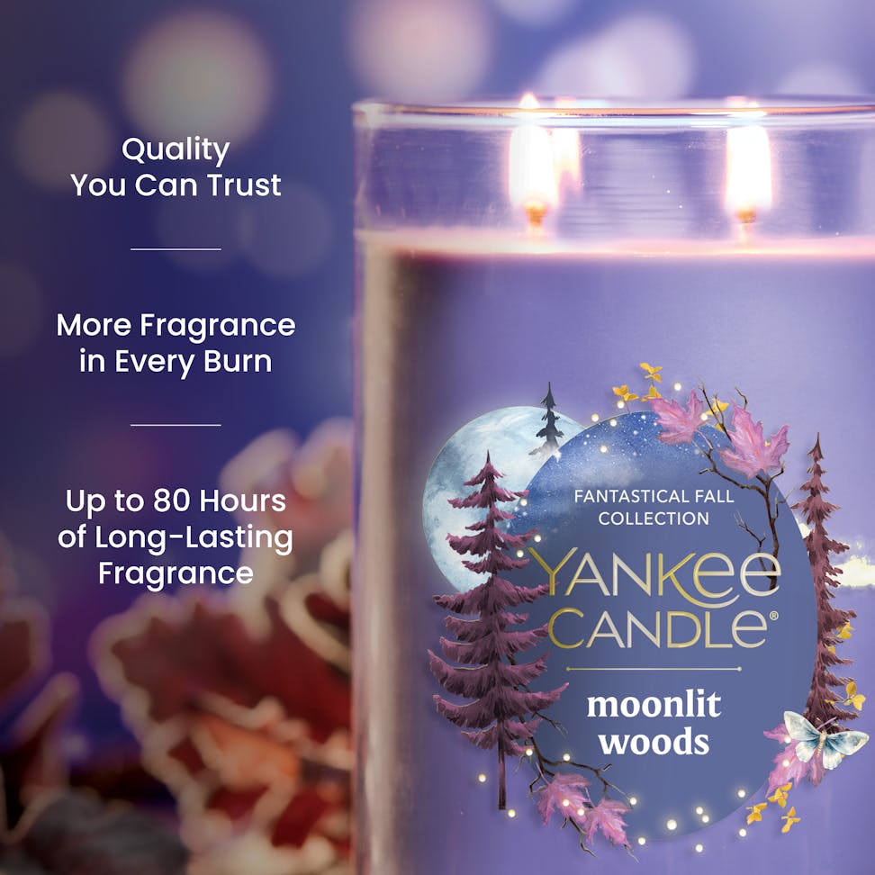 Purple scented candle in glass jar with three wicks, autumn leaves, and text highlighting fragrance and burn time.
