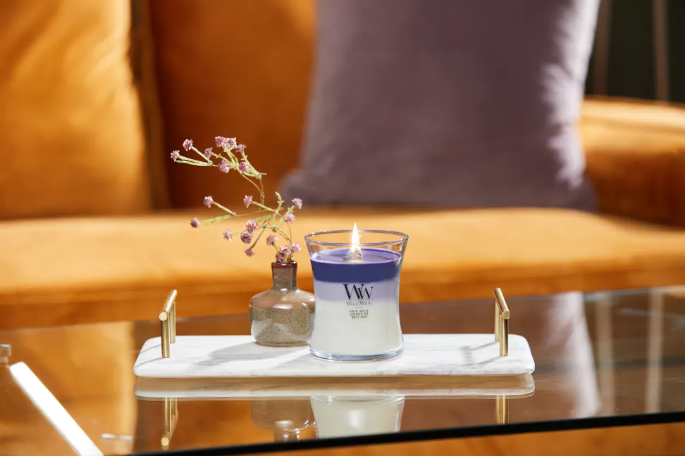 purple trilogy medium hourglass candle on stone tray with small vase and flowers on glass coffee table