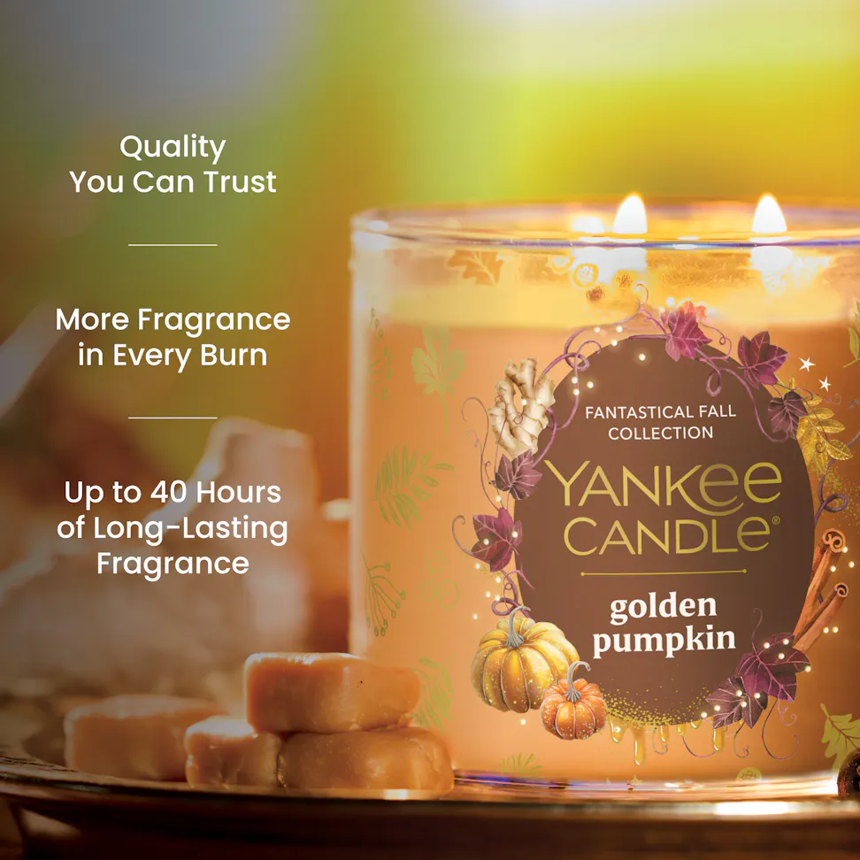 Large pumpkin-scented candle in glass jar with fall decor, caramel candies, and long-lasting fragrance text.