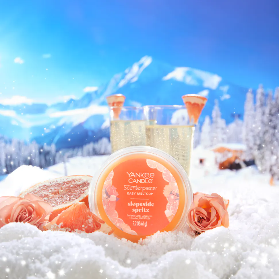 slopeside spritz easy meltcup on a snowy mountainside with sliced grapefruit roses and glasses of sparkling wine