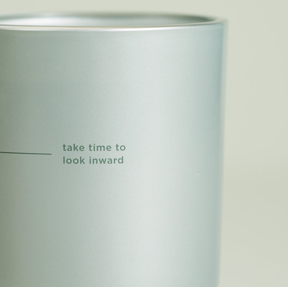 chesapeake bay candle intentions collection be reflective cucumber matcha medium two wick candle in a pastel teal backdrop