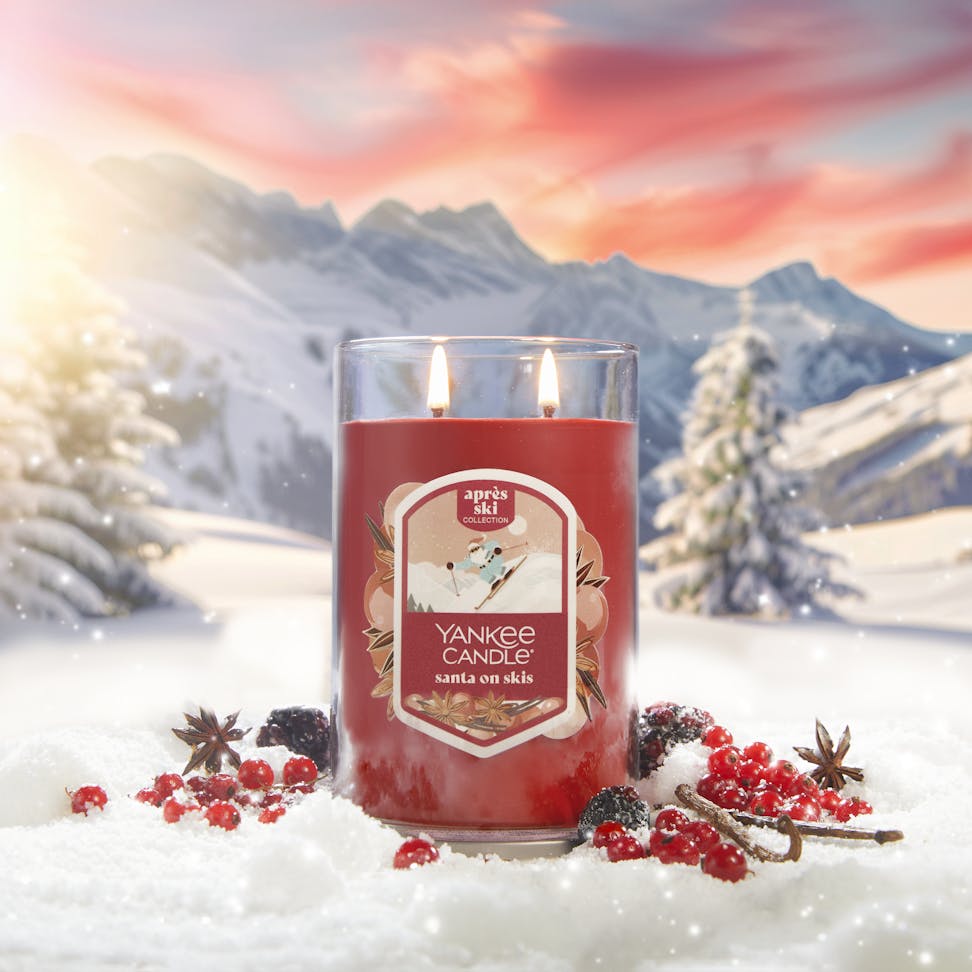 Apres Ski Collection Santa on Skis Signature Large Tumbler Candle in snow surrounded by berries, spices, and mountains