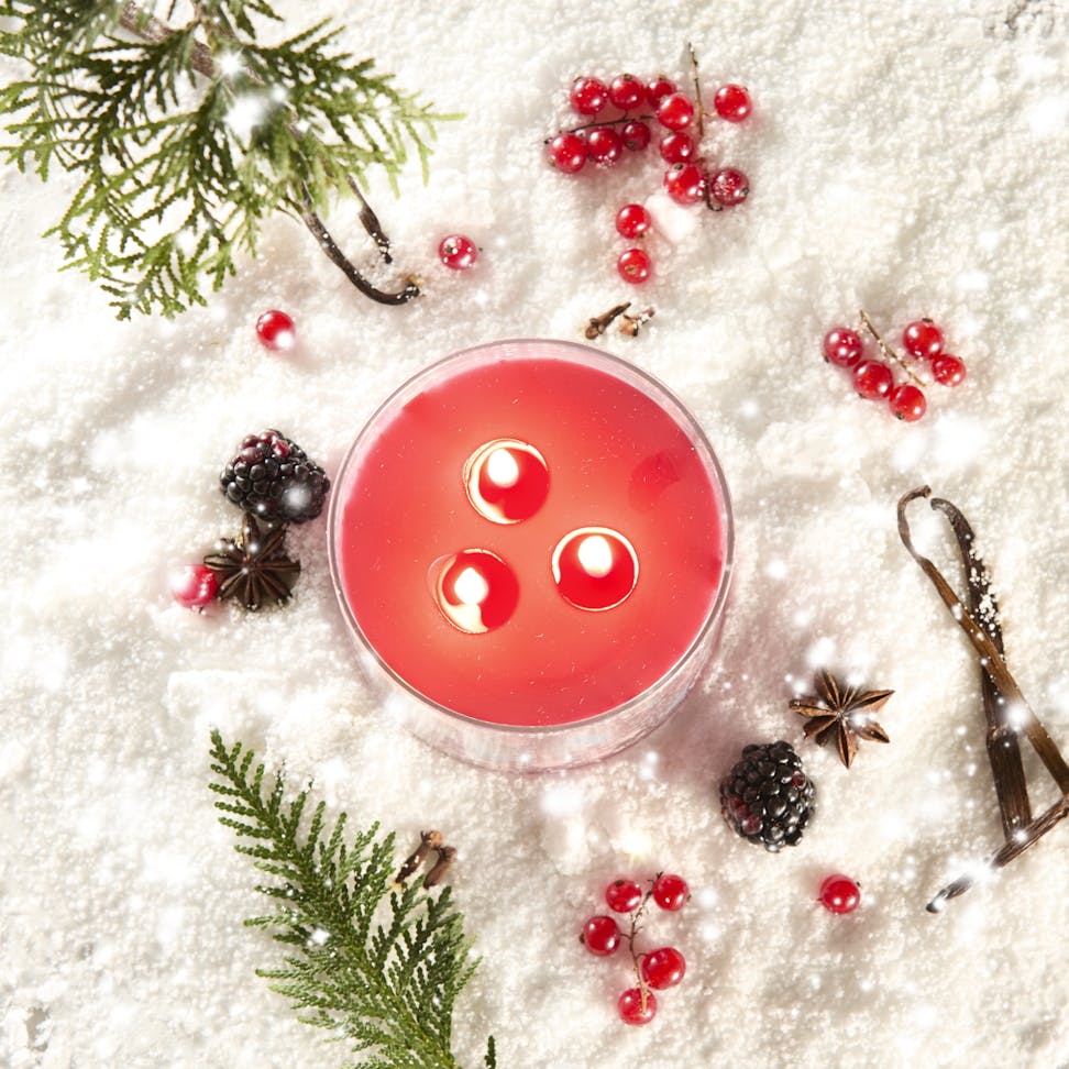 Apres Ski Collection Santa on Skis 3-Wick Candle in snow surrounded by berries and spices