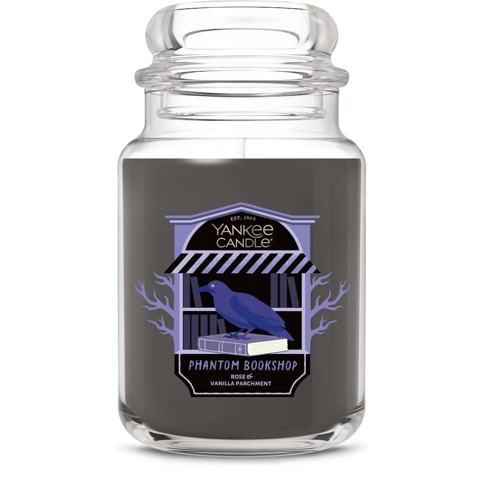 Large black scented candle in glass jar with raven and bookshop illustration, home fragrance decor