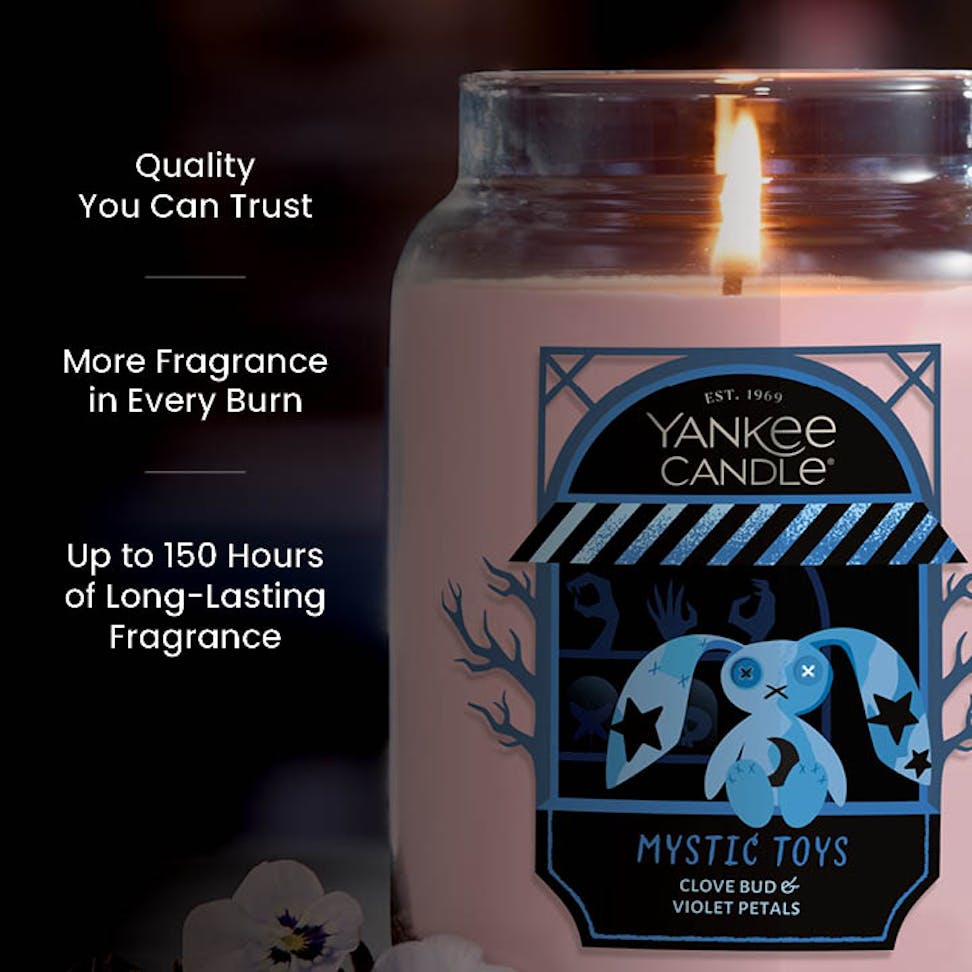Large scented candle in glass jar with label, lit and burning, text highlights quality and long-lasting fragrance.